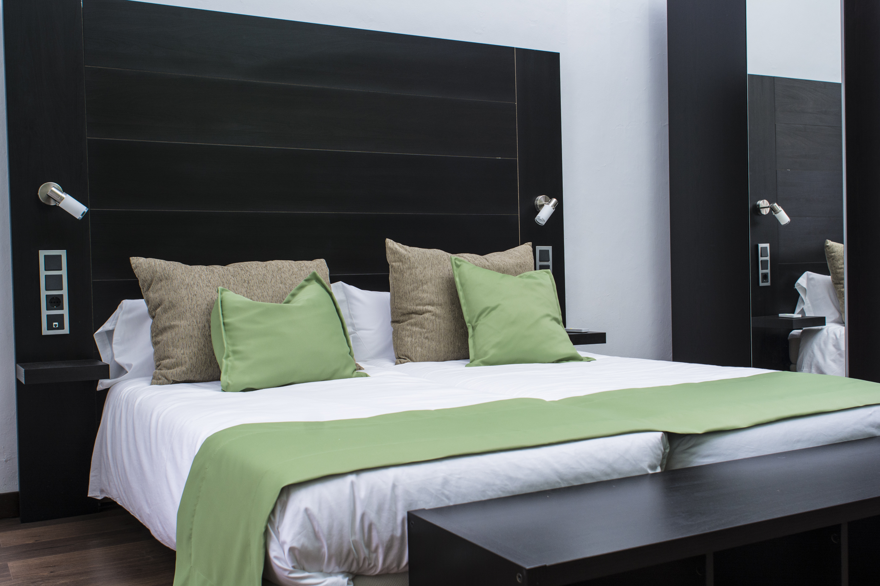 Habitación del hotel con cama y cojines verdes